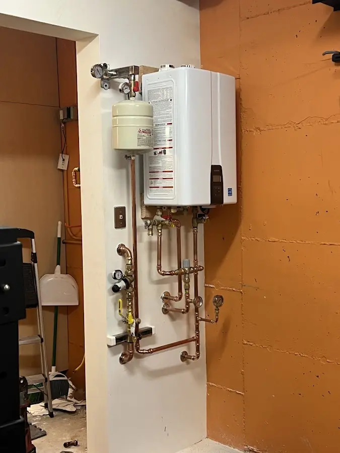 Plumbing technician inspecting water heater connections in Florham Park